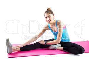 Fit woman stretching on exercise mat