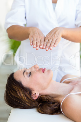 Calm woman receiving reiki treatment