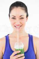 Beautiful woman drinking green juice