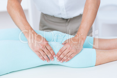 Physiotherapist doing leg massage to his patient