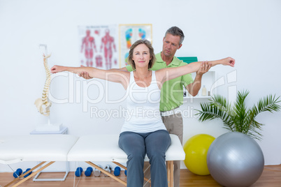 Doctor stretching his patients arms