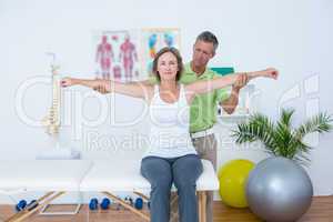 Doctor stretching his patients arms