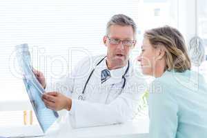 Doctor having conversation with his patient and holding xray