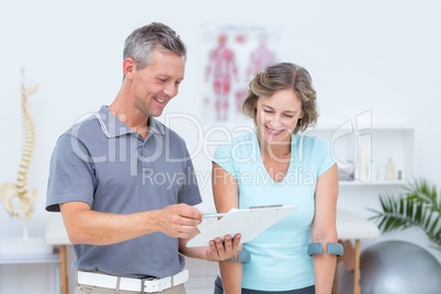 Woman using crutch and talking with her doctor