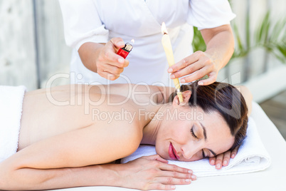 Relaxed brunette getting an ear candling treatment