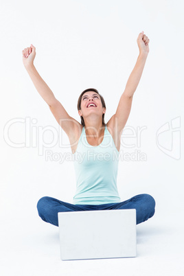 Excited woman with laptop raising her arms