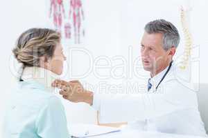 Doctor checking neck brace of his patient