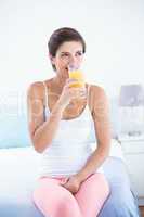 Attractive woman taking drinking glass of orange juice
