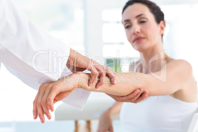 Doctor examining her patients elbow