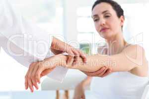 Doctor examining her patients elbow