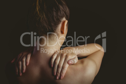 Nude woman with a shoulder injury