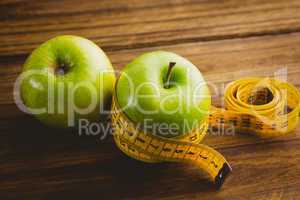 Green apples with measuring tape