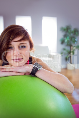 Fit woman leaning on exercise ball