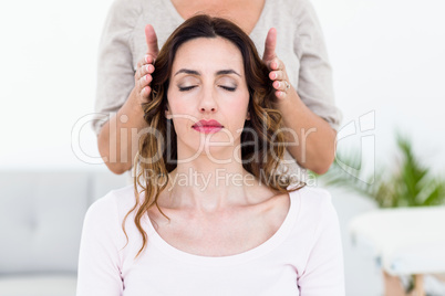 Calm woman receiving reiki treatment