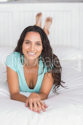 Happy brunette lying on bed