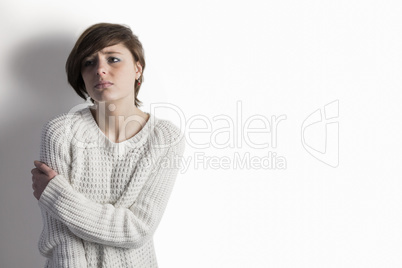 Sad pretty brunette leaning against wall