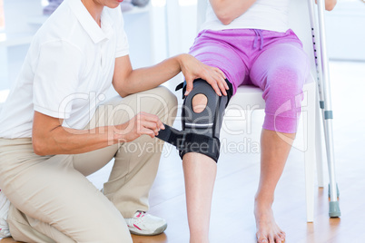 Doctor examining her patients knee