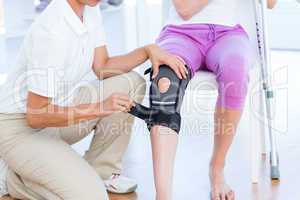 Doctor examining her patients knee