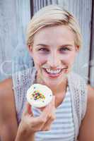 Pretty blonde woman holding cupcake