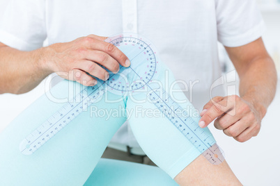 Doctor measuring knee with goniometer