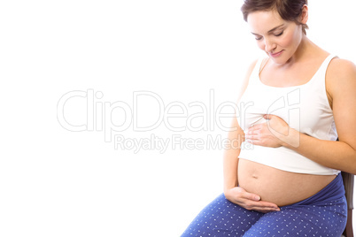 Pregnant woman smiling at bump