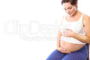 Pregnant woman smiling at bump