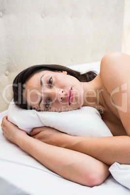 Pretty brunette trying to sleep on bed
