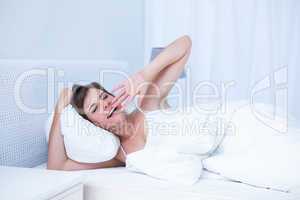 Beautiful woman yawning in her bed