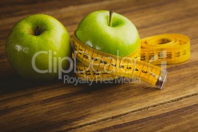 Green apples with measuring tape