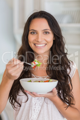 Pretty brunette eating a salad