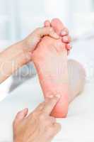 Physiotherapist massaging her patients foot