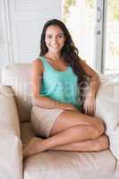 Pretty brunette sitting on the armchair