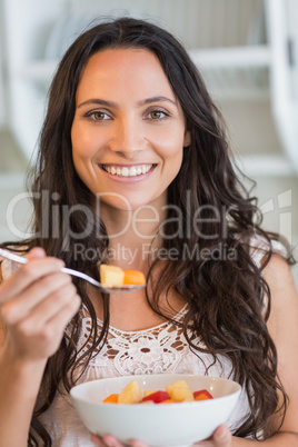 Pretty brunette  eating a fruits salad