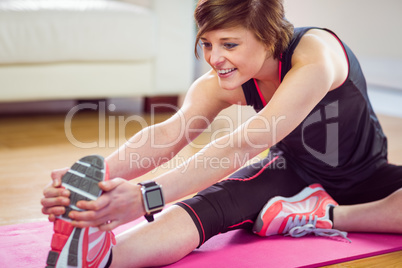 Fit woman stretching on exercise mat