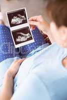 Pregnant woman looking at ultrasound scans