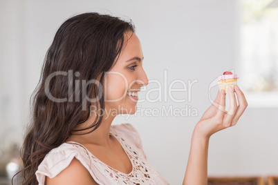 Beautiful brunette holding mini cupcake
