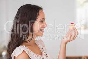 Beautiful brunette holding mini cupcake