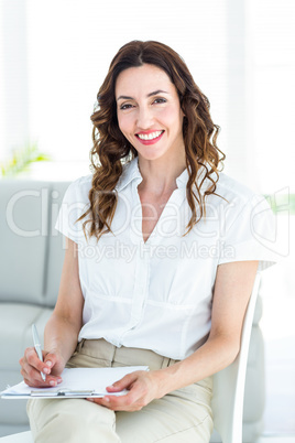 Smiling therapist taking notes