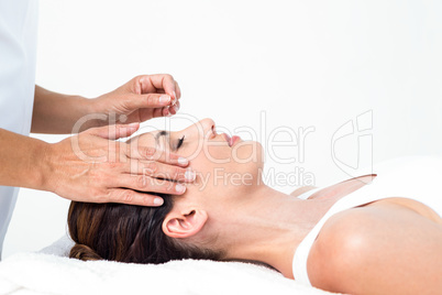 Relaxed woman receiving an acupuncture treatment