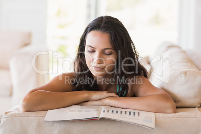 Pretty brunette reading magazine on the couch