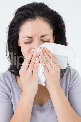 Sick brunette blowing her nose