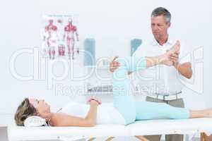 Doctor stretching his patients leg