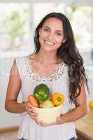 Beautiful brunette holding vegetables bowl