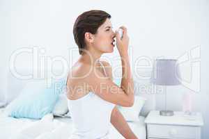 Pretty brunette taking her inhaler