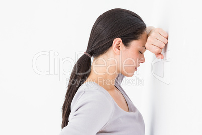 Sad woman leaning against the wall