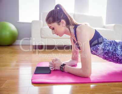 Fit woman doing plank on mat