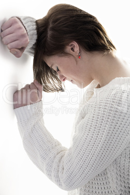 Sad pretty brunette leaning against wall