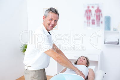 Physiotherapist doing stomach massage to his patient