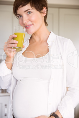 Pregnant woman drinking glass of orange juice