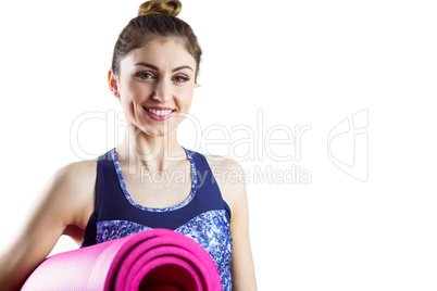 Fit brunette holding yoga mat
